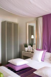 a bedroom with a bed with purple and white pillows at Quinta da Lua in Tavira