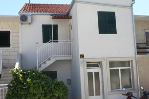 une maison blanche avec un escalier et une fenêtre dans l'établissement Apartment Irena Bol, à Bol