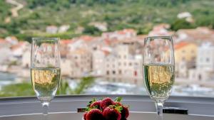 two glasses of champagne and a flower on a window sill at The Little Gem in Komiža