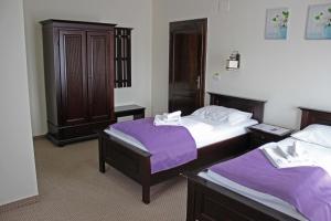 Habitación de hotel con 2 camas con sábanas moradas en Pensiunea Casa Iorgovanul Urseni en Timişoara