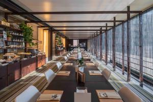 a long row of tables in a restaurant at UNAHOTELS One Siracusa in Syracuse