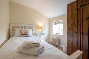 1 dormitorio con 1 cama con toallas en Little Tern Cottage, en Aldeburgh
