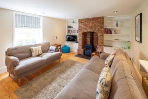sala de estar con sofá y chimenea en Little Tern Cottage, en Aldeburgh