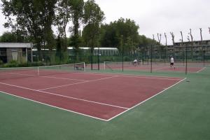 zwei Personen, die Tennis auf einem Tennisplatz spielen in der Unterkunft Appartement Dahlia Garden 8p in De Haan
