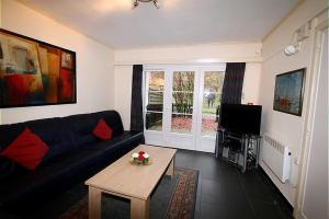 ein Wohnzimmer mit einem Sofa und einem Tisch in der Unterkunft Appartement Dahlia Garden 8p in De Haan