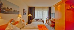a hotel room with a bed and a desk at Trip Inn Hotel Zum Riesen Hanau in Hanau am Main +60 photos