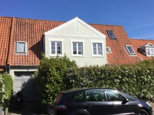 een auto geparkeerd voor een wit huis bij 4 Louisenlund in Skanderborg