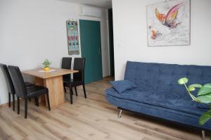 Rooms Hiša Divino في بتوي: غرفة معيشة مع أريكة زرقاء وطاولة