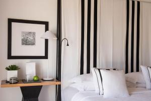 a bedroom with a bed and a table with a lamp at Quinta da Lua in Tavira