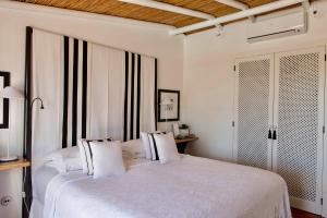 a bedroom with a white bed with white pillows at Quinta da Lua in Tavira