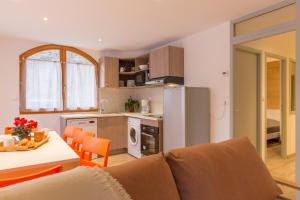 een keuken en een woonkamer met een bank en een tafel bij Le Signal du Prorel in Briançon