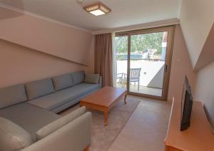 a living room with a couch and a tv at Hotel Aqua in Marmaris