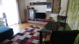 a living room with a table and a tv at Ferien Wohnung "Kaiser" mit Balkon und Garten in Offenhausen