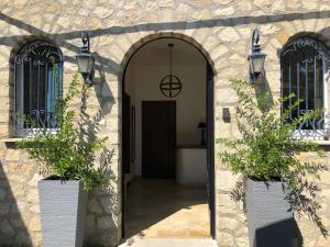 una entrada a un edificio de piedra con dos macetas en La Maison des Brandes, en Eynesse