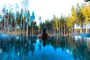 Eine Frau im Wasser mit Bäumen im Hintergrund in der Unterkunft Center Parcs Park Allgäu in Leutkirch im Allgäu