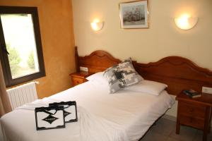 a bedroom with a white bed with two pillows on it at Hotel Sucara in Ordino