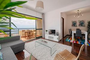 ein Wohnzimmer mit einem Sofa und einem Esszimmer in der Unterkunft Garajau II by An Island Apart in Caniço