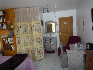 Le Verger du Sausset في بون: غرفة معيشة مع مطبخ وغرفة طعام