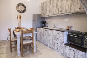 a kitchen with a table and a clock on the wall at Studio Galatia, in the heart of Kamilari in Kamilari