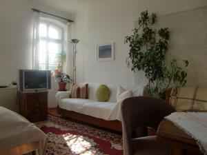 a living room with a white couch and a tv at Ferienwohnung A3 in Klocksin