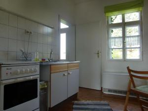 eine Küche mit einem Herd, einem Waschbecken und einem Fenster in der Unterkunft Ferienwohnung A3 in Klocksin