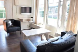 a living room with a couch and a table at Heuveltjes 4 pers. bungalow in Voorthuizen