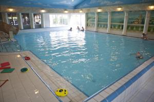 a large swimming pool with people in the water at Heuveltjes 4 pers. bungalow in Voorthuizen +10 photos