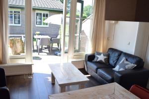 a living room with a couch and a table at Heuveltjes 4 pers. bungalow in Voorthuizen