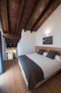 a bedroom with a large bed with wooden ceilings at Old Town Flats Casa Burguerini in Valencia