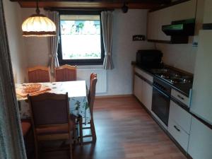 a kitchen with a table and a stove and a window at Holiday park- Robinson in Waldbrunn