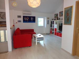 a living room with a red couch and a table at Modern apartmant in old city in Piran
