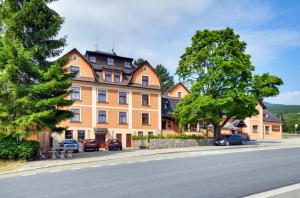 een groot oranje gebouw aan de straatkant bij Hotel Stara Posta in Filipovice