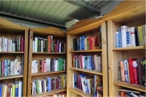 una fila de estanterías de madera llenas de libros en Holiday park- Winnetou en Waldbrunn