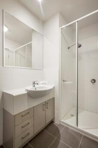 a white bathroom with a sink and a shower at Quest Ipswich in Ipswich