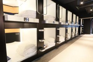 a row of bunk beds in a dorm room at ビジネスカプセルホテル Lightning Hotel浅草 in Tokyo