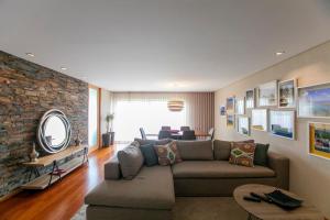 un salon avec un canapé et un mur de briques dans l'établissement Comfy Luxury Apartment, à Porto