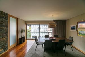 une salle à manger avec une table et des chaises et une grande fenêtre dans l'établissement Comfy Luxury Apartment, à Porto