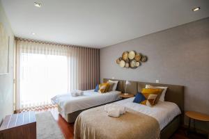 ポルトにあるComfy Luxury Apartmentのベッド2台と窓が備わるホテルルームです。