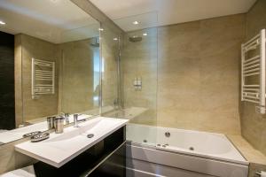 une salle de bain avec une baignoire, un lavabo et une douche dans l'établissement Comfy Luxury Apartment, à Porto 30 autres photos