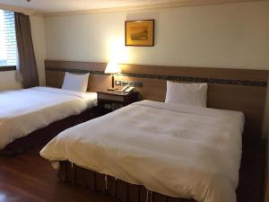 Postel nebo postele na pokoji v ubytování SunWang Hotel