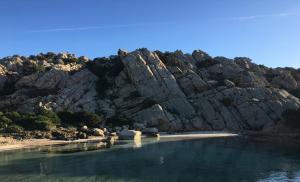 una ladera rocosa con un cuerpo de agua en Dimora Conte en La Maddalena