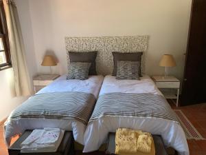 a bedroom with two beds and two tables with lamps at Quinta Santa Isabel in Chaves