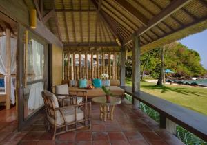a screened porch with a table and chairs and a view at Jeeva Klui Resort in Senggigi