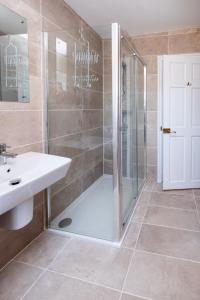 a bathroom with a shower and a sink at Rowan – Three Tuns Apartments in Pettistree