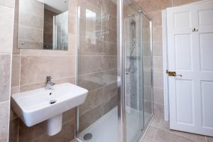 a bathroom with a sink and a shower at Rowan – Three Tuns Apartments in Pettistree