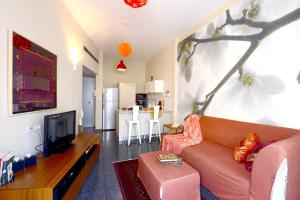 a living room with a couch and a tv at King George Apartments in Tel Aviv