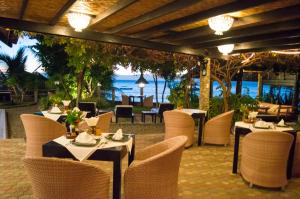 restauracja ze stołami i krzesłami z widokiem na ocean w obiekcie Dolphin House Resort Moalboal w mieście Moalboal