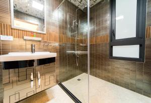 un bagno con lavandino e doccia in vetro di Sky Young Homestay a Città Vecchia di Hengchun