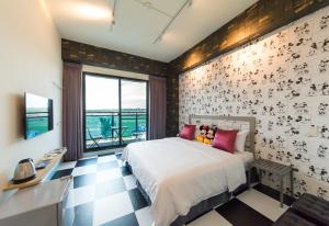 una camera da letto con un letto e un pavimento a scacchi di Sky Young Homestay a Città Vecchia di Hengchun