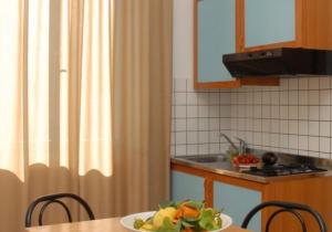 a kitchen with a table with a bowl of fruit on it at Residence Ducale in Rodi Garganico